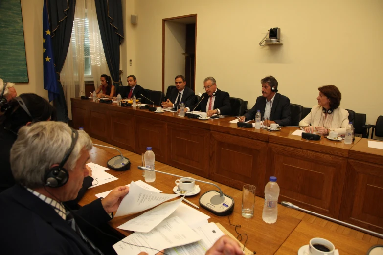 a group of business people sitting around a table with papers