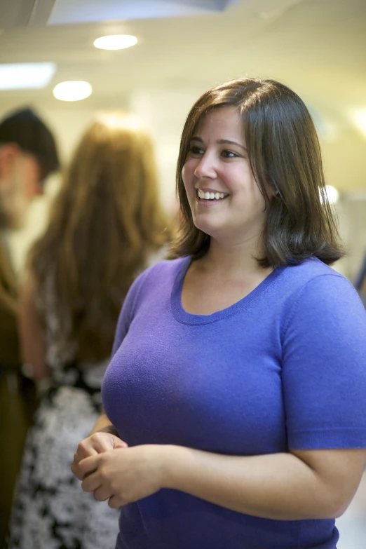 the smiling woman with her hands crossed smiles