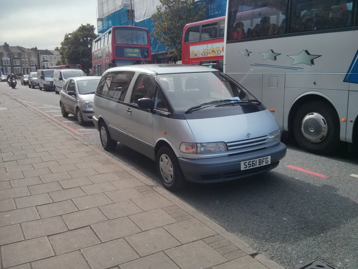 a busy city street with buses, cars, and people