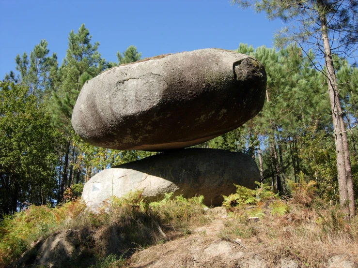 a large rock is standing on the ground