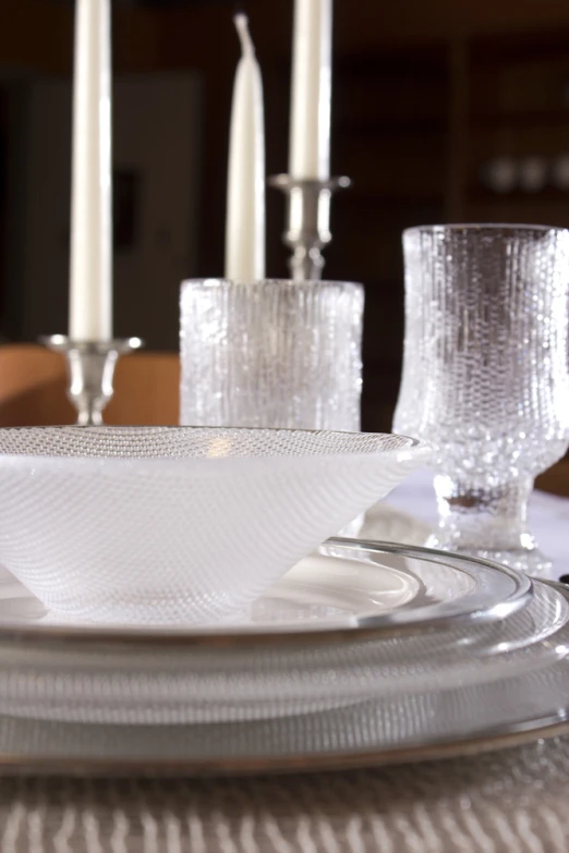 glass plates with silver dishes sitting on a dining room table