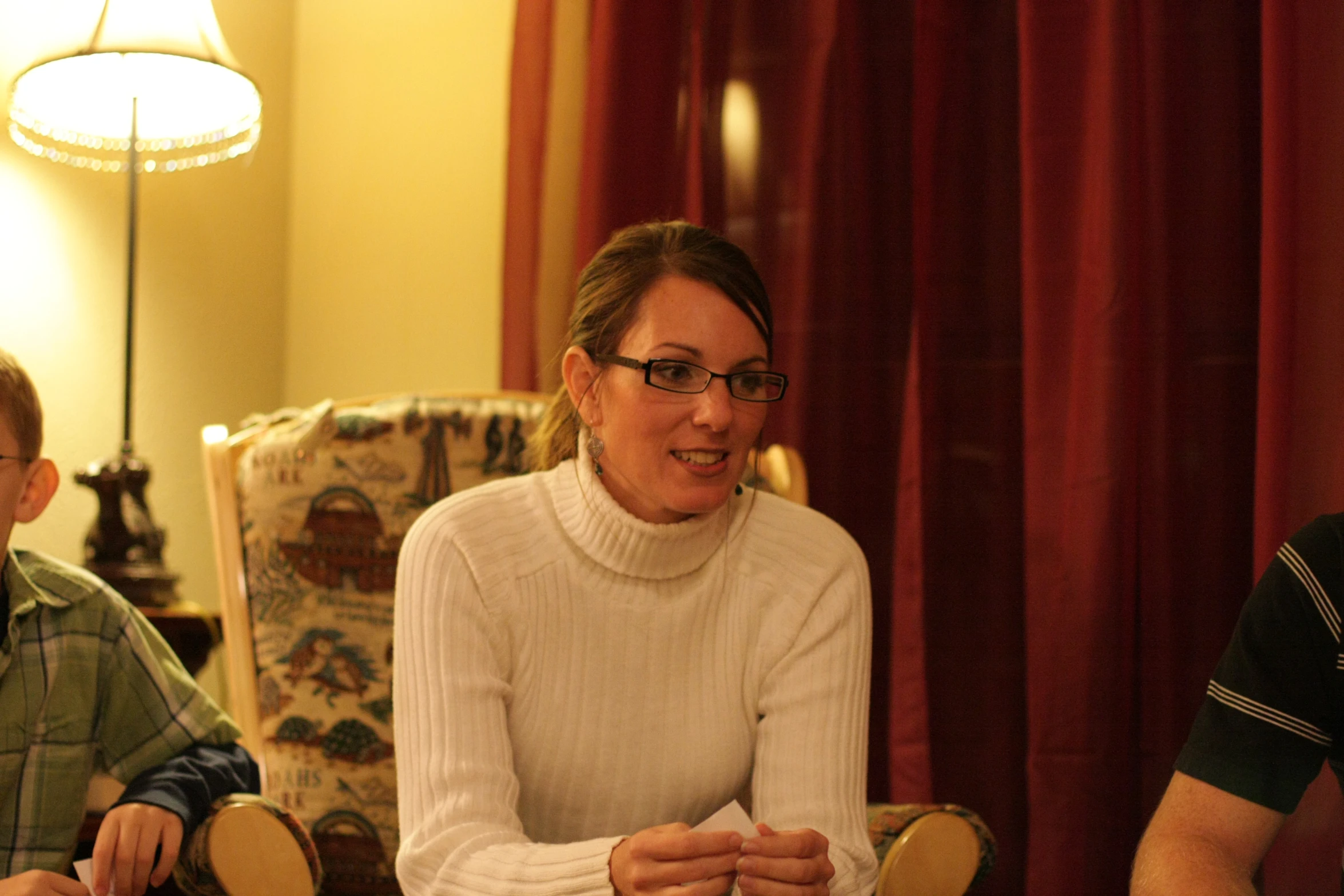 two men and a woman sitting in a living room