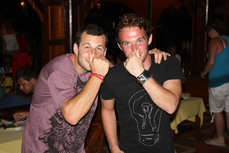 a couple of men standing in front of a table