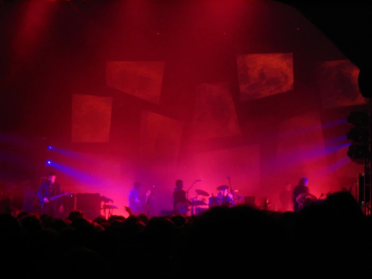 the band performing on stage under bright red lights