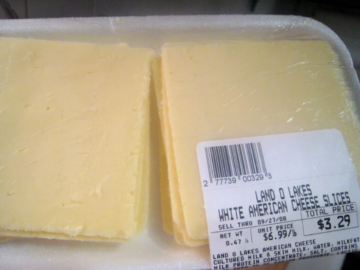 two pieces of cheese in plastic trays with a price label