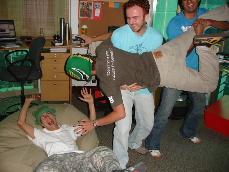 two men in a room with desks and a woman on the floor