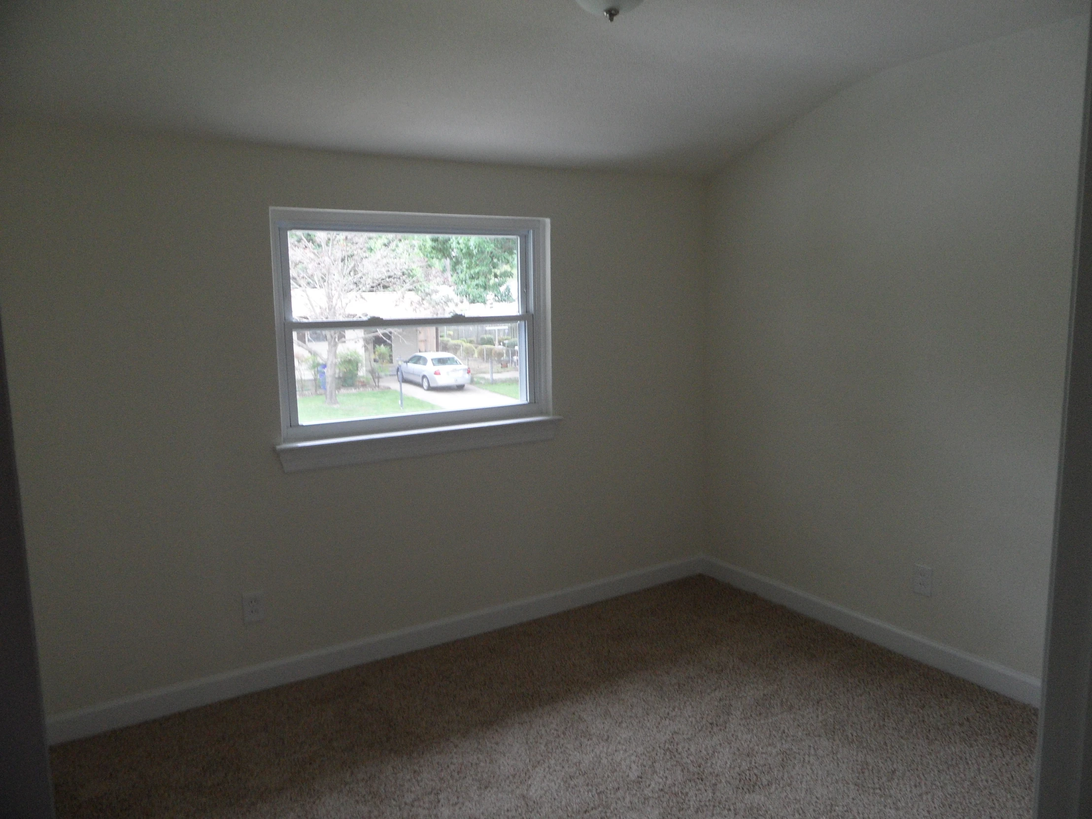 a empty room with a window and small door