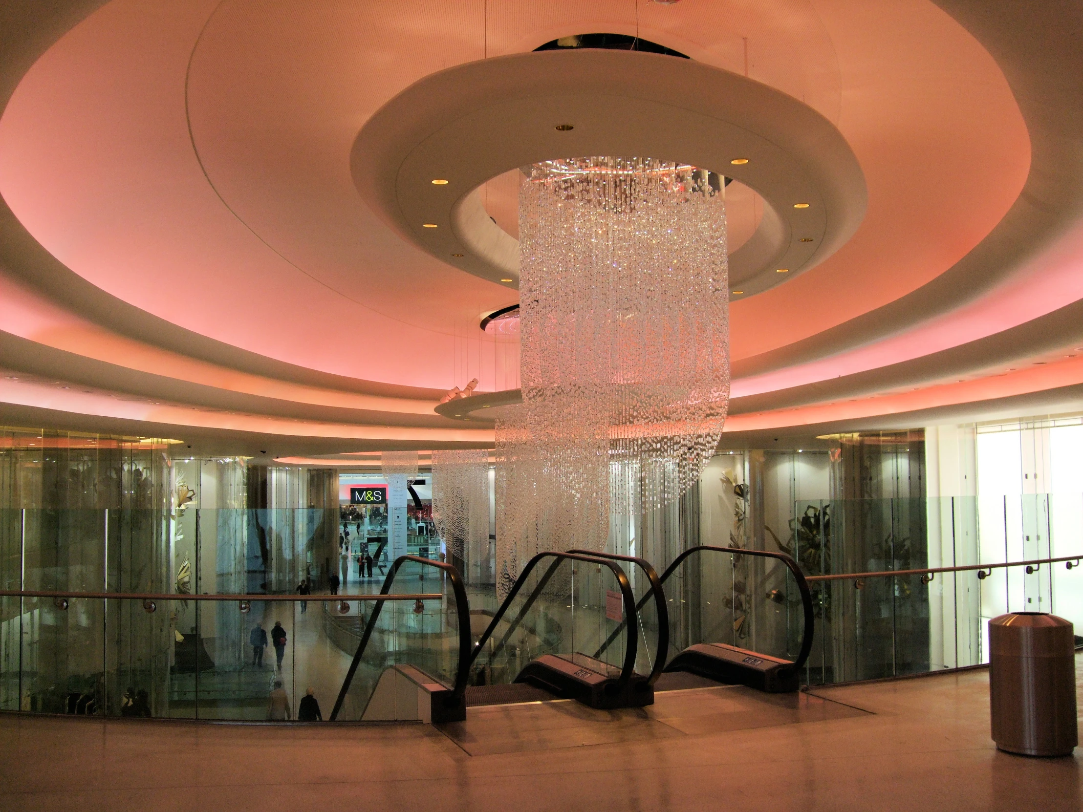 a huge lobby with stairs and a glass chandelier