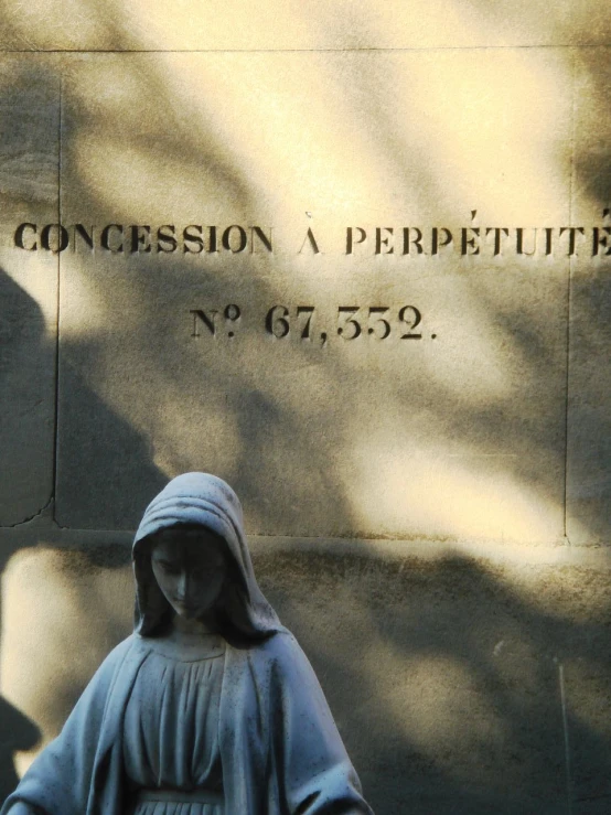 a statue that is wearing a robe next to a building