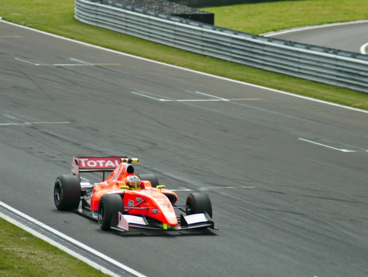 the driver of a racing car drives down a race track
