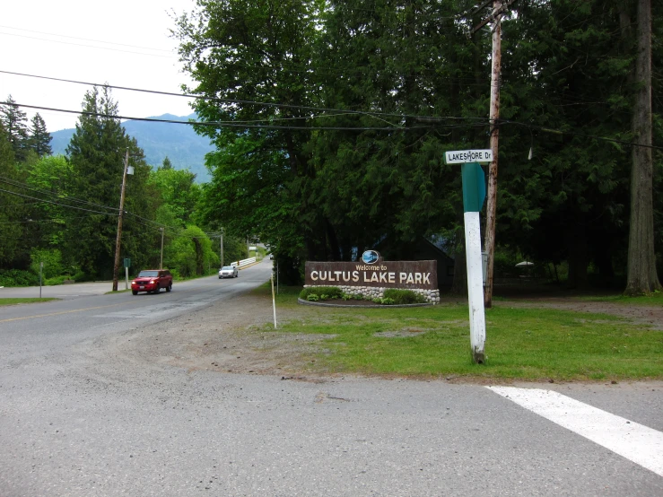 the car is traveling down the road by the entrance