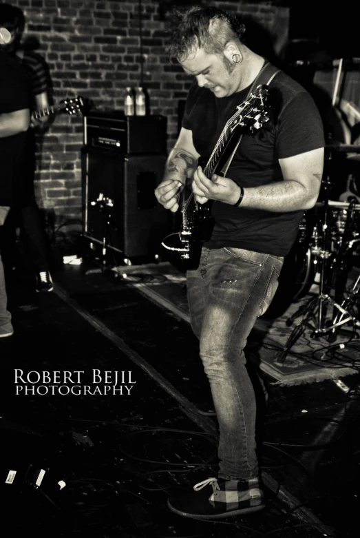 a man standing on a stage with his guitar