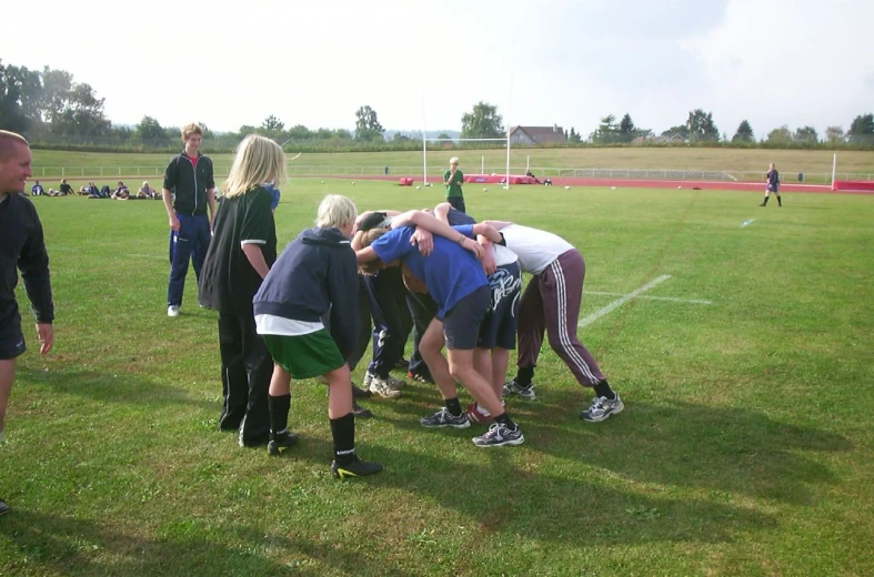 there are some people huddled on a field together