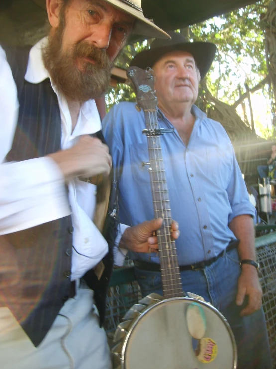 two men dressed as cowboys and one has a blue shirt on