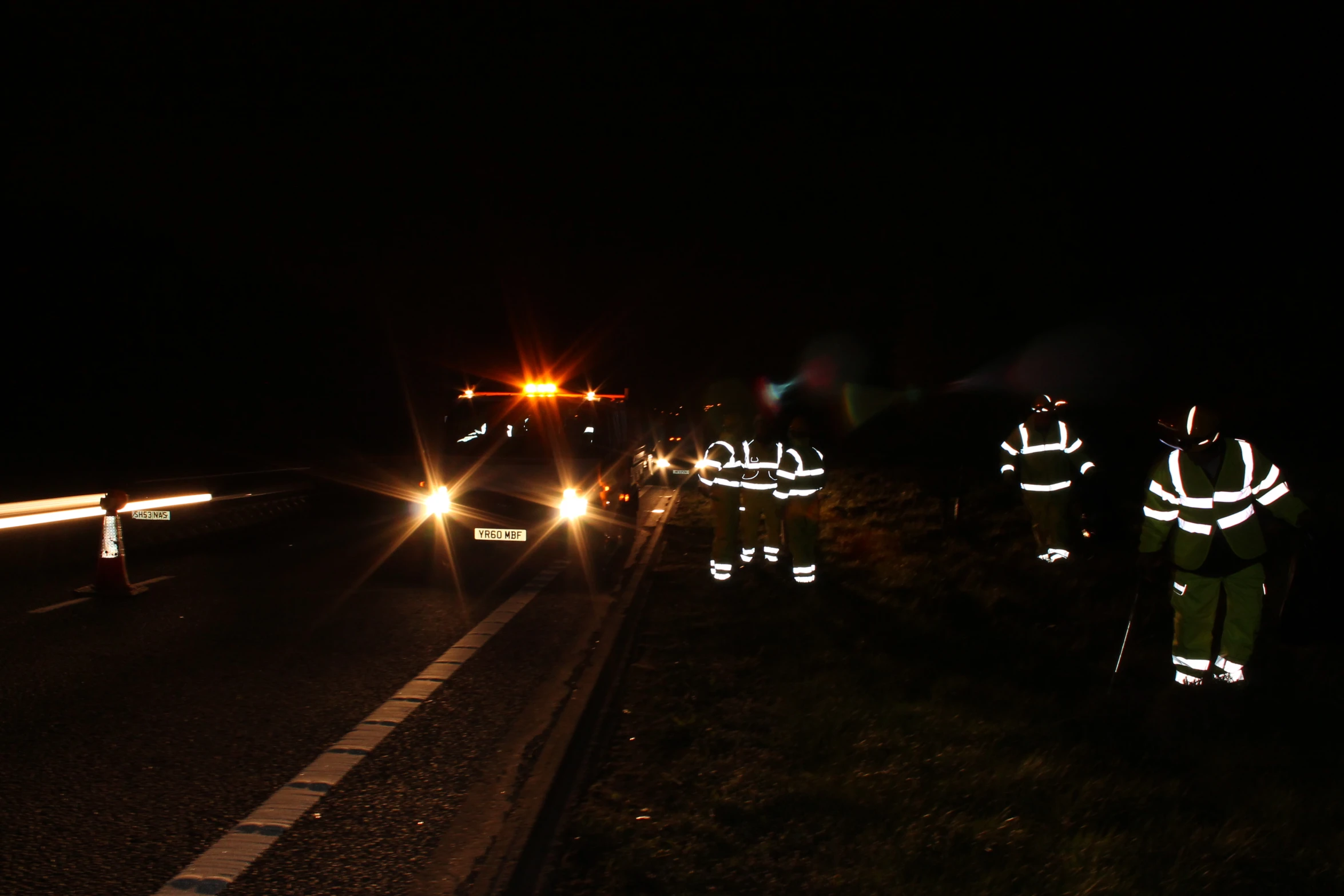 traffic on a dark highway at night with lights on