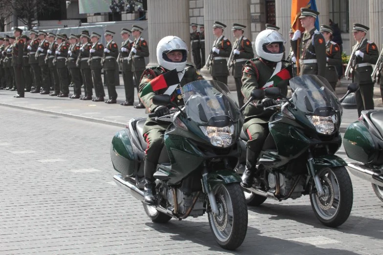three motorcycles are riding side by side while in uniform
