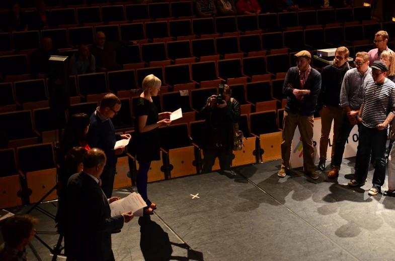 people standing on the stage in an auditorium