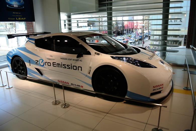 the white sports car is on display inside a building