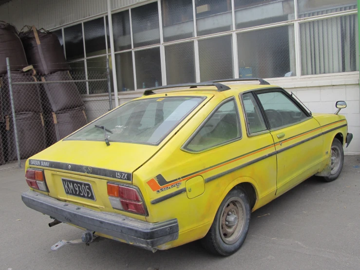 the yellow car is parked outside a building