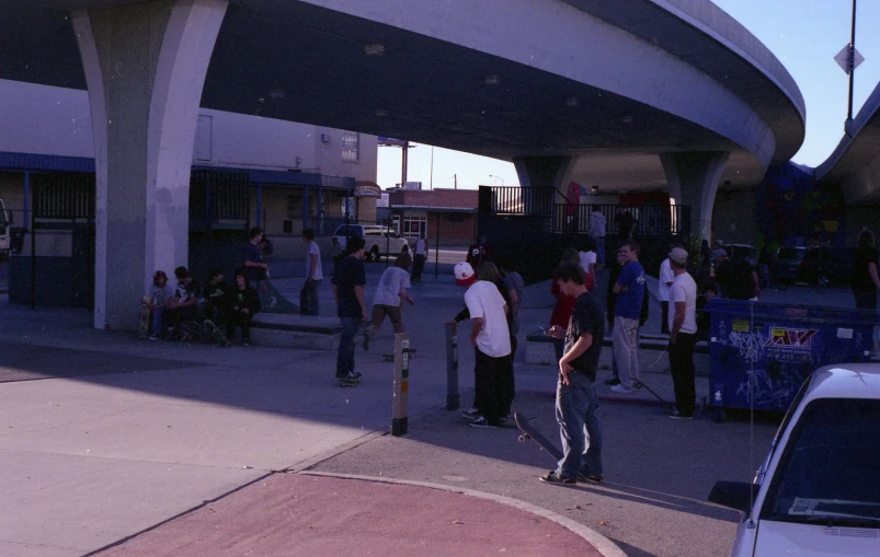 a man on a skateboard waits by some parking spots