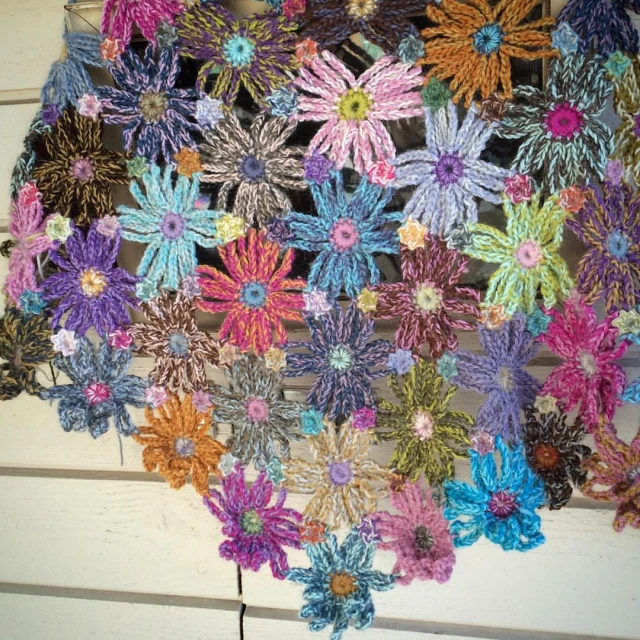 crochet flowers in different colors arranged on top of each other