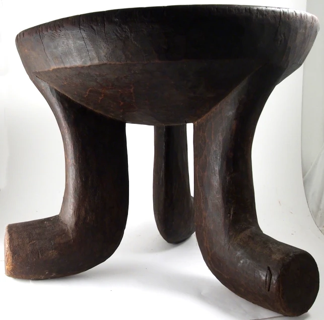 a wooden bowl shaped sculpture sitting on top of a white floor