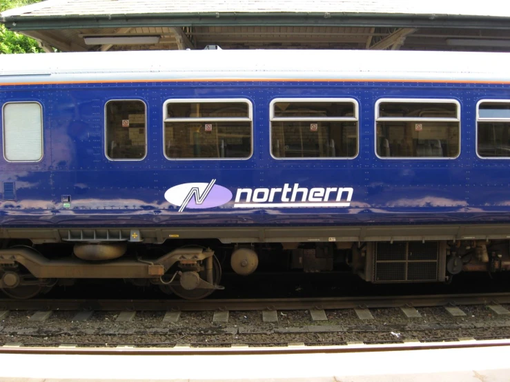 a train car parked on railroad tracks near a building