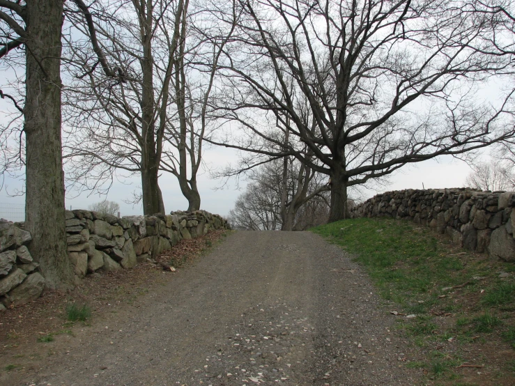 a dirt road surrounded by dry stone walls