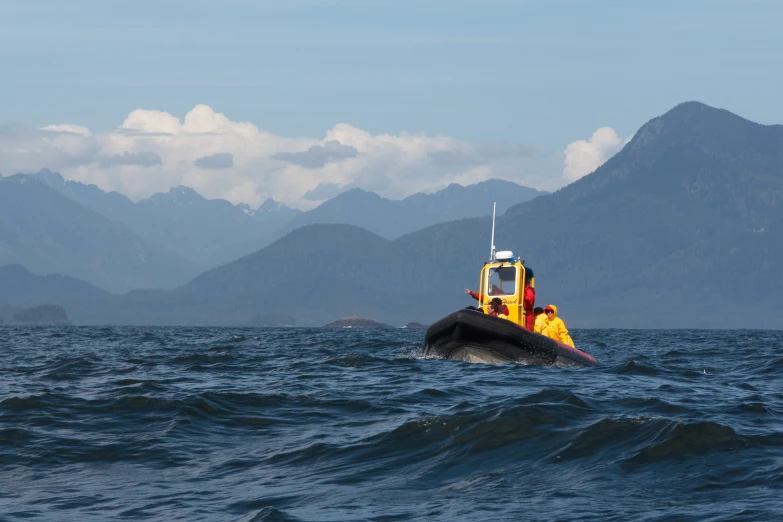 a small coast guard boat with mountains in the background