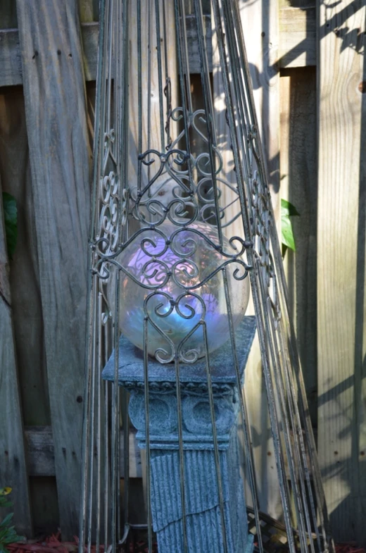 an old iron birdcage with purple glass and swirl decorations