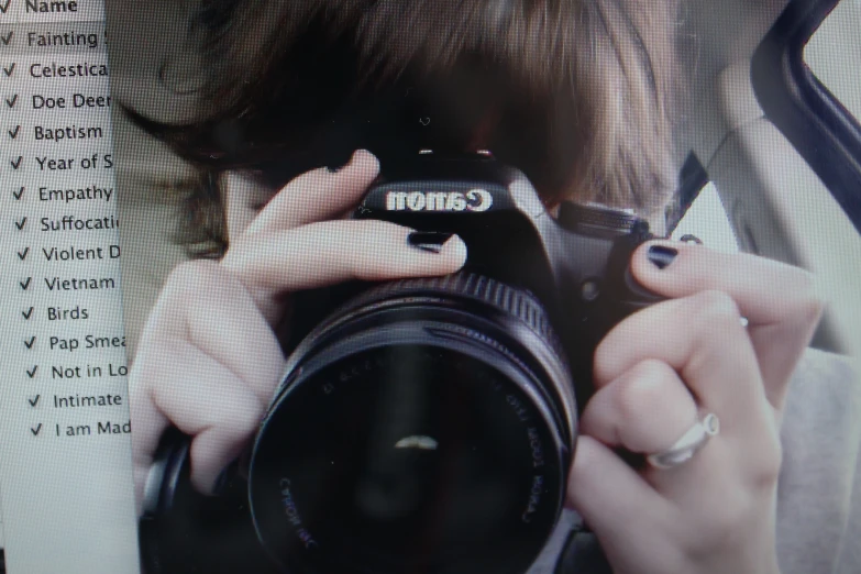 a camera woman holding a canon camera