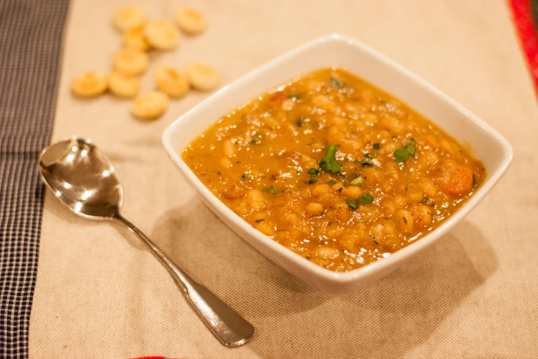 a white bowl containing soup and a spoon