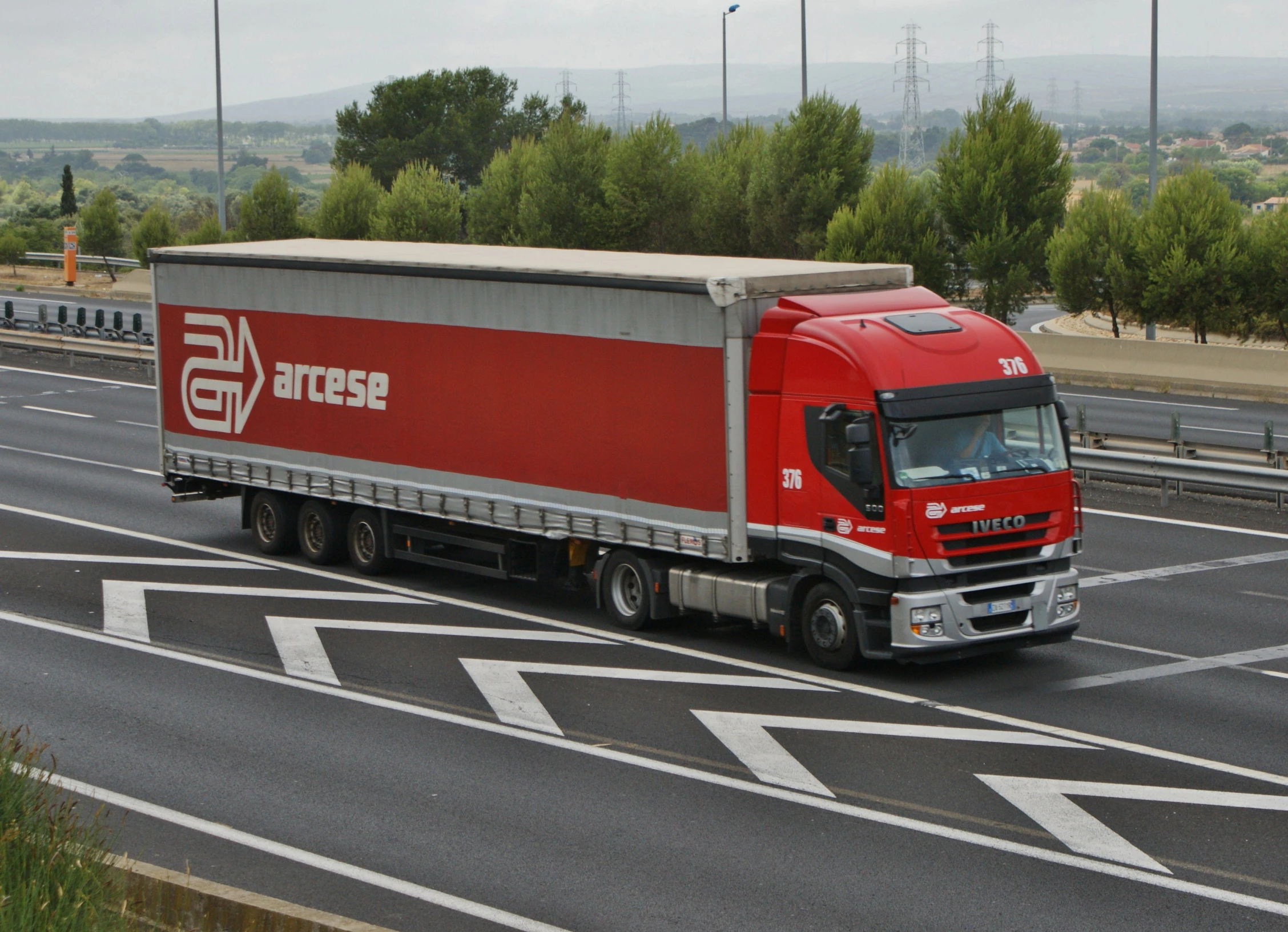 a large truck on a city highway near a grass area