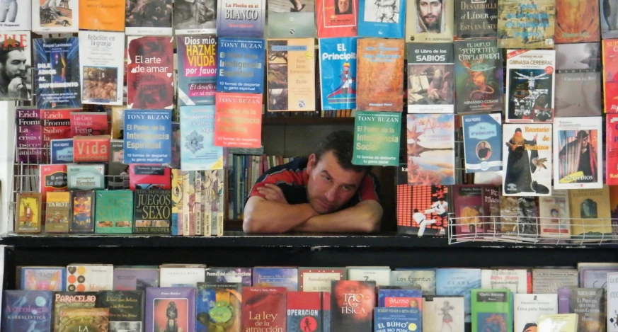 the young man is leaning his head against a display rack