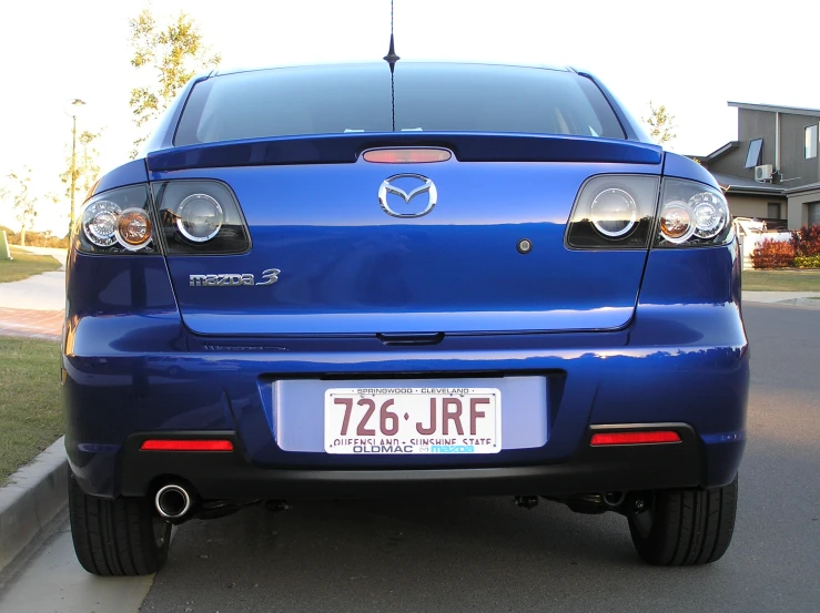 mazda is sitting in front of a house