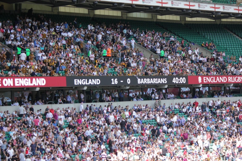 large group of spectators sitting in front of an empty stadium