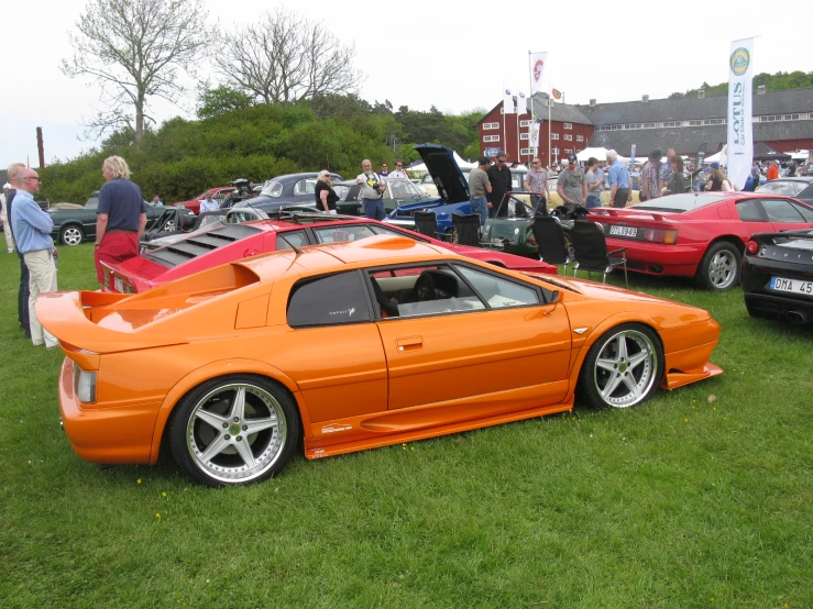 the large orange sports car is parked in the grass