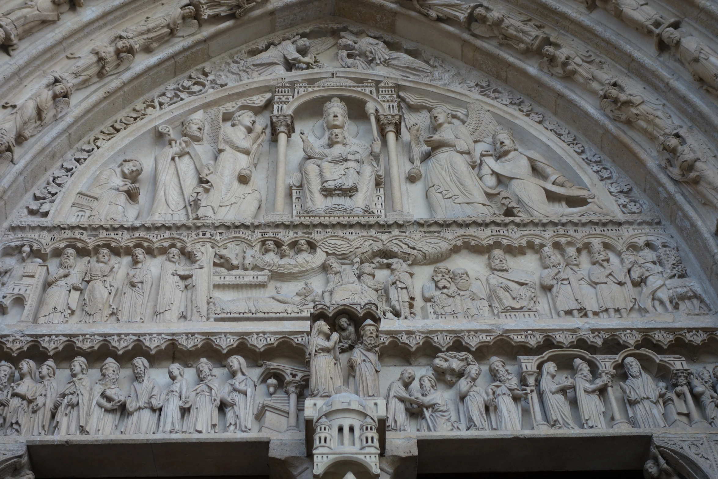 a sculpture of people on a building by itself