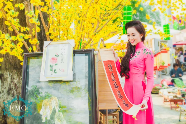 asian woman holding an oriental banner beside an easel