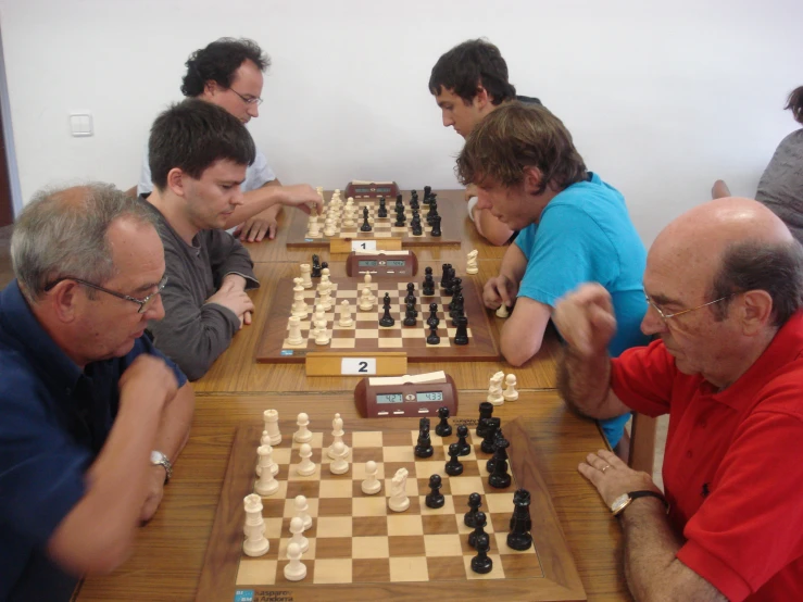 several men sit at a table playing a game