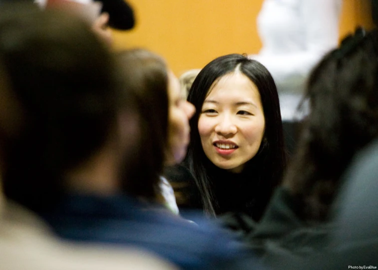 a woman is smiling and talking to others