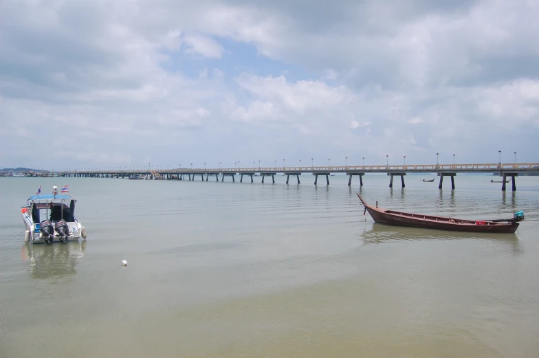 two boats in the water by a pier