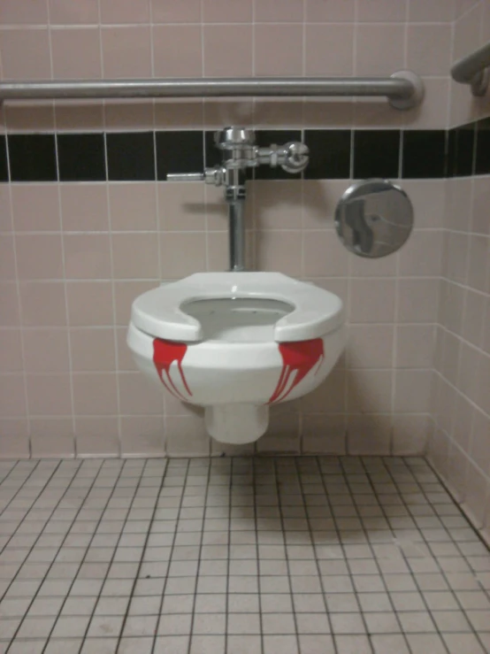 the red and white toilet has red designs on it
