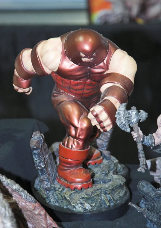 an action figure wearing red armor with his fist out, standing on a black surface