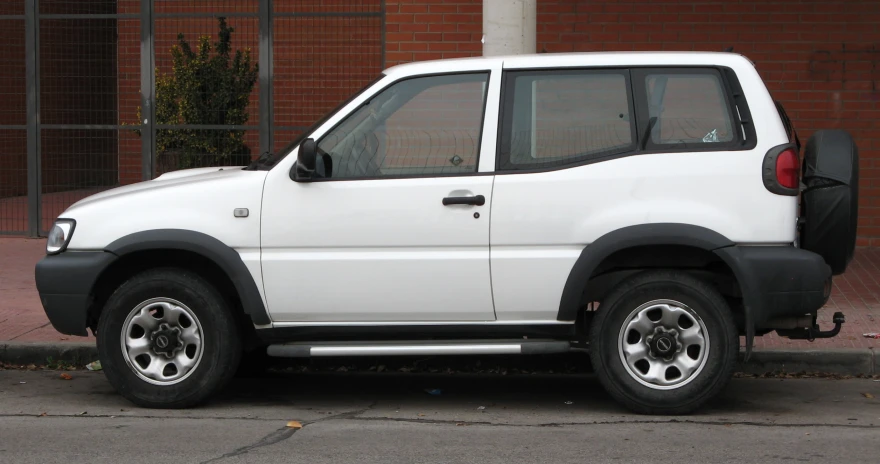 a white four door compact car is parked on the street