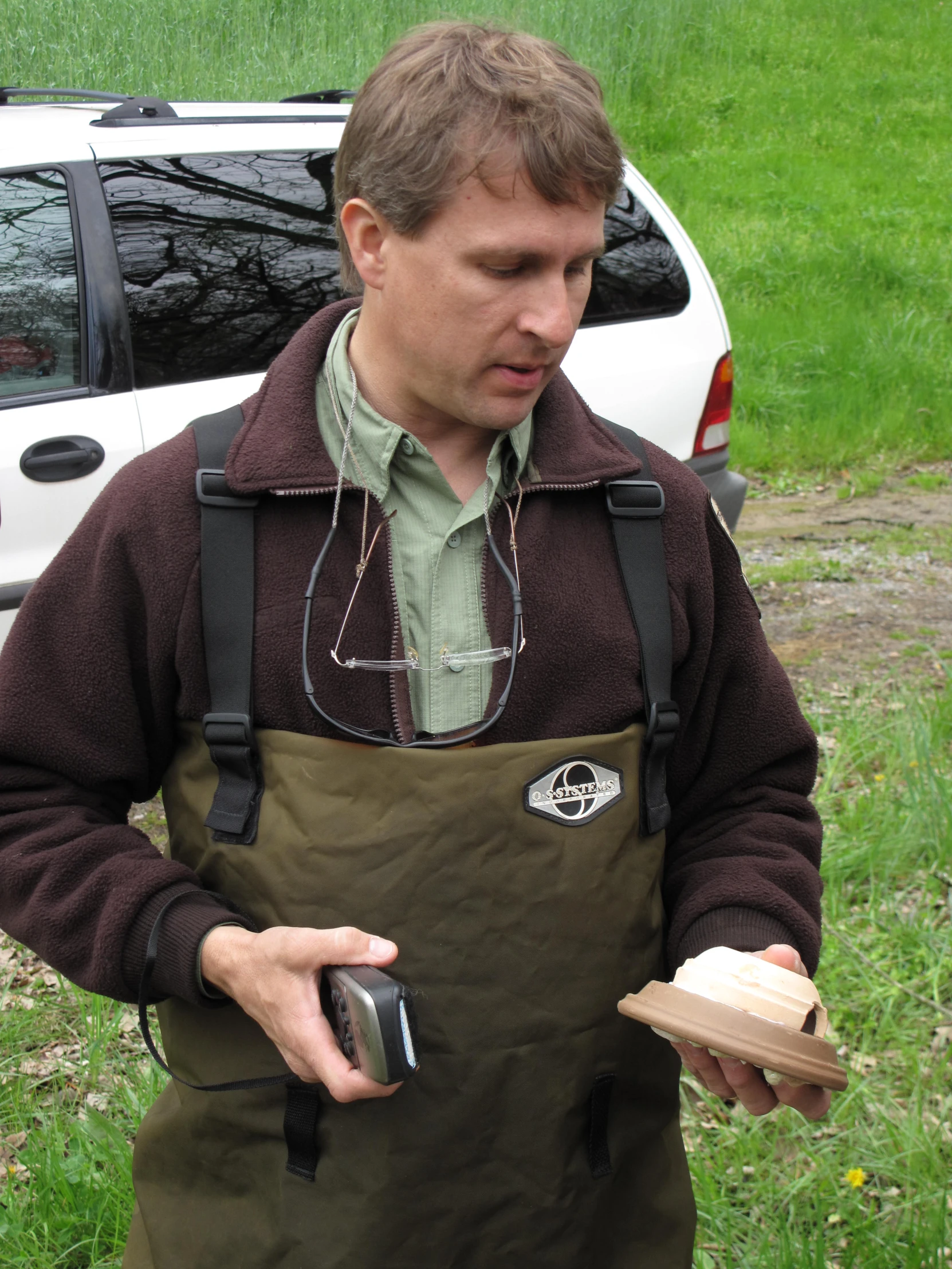 a man is holding an item and wearing an apron