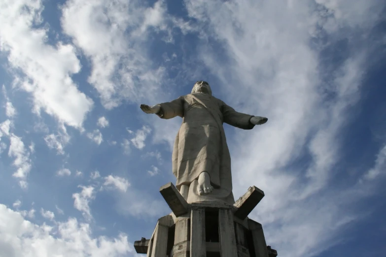 a large statue of jesus standing at the base of a tall structure