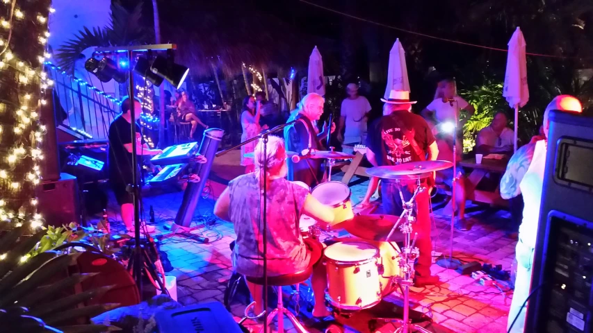 a man is playing drums on stage with other people