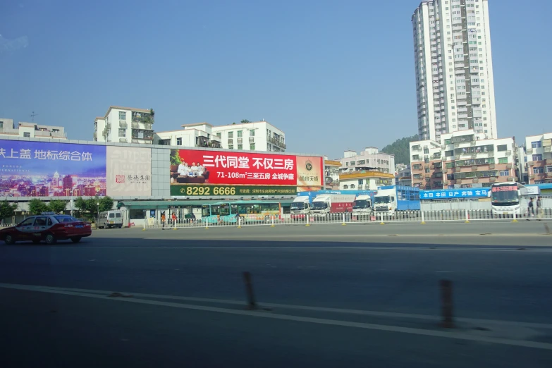 an over pass and a city street, a car driving down the road and tall buildings