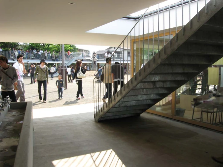 people walking around an open building next to steps